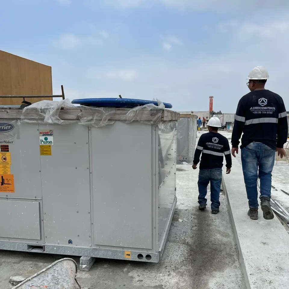 Técnicos de Airecontrol caminan entre los equipos de aire acondicionado de una terraza