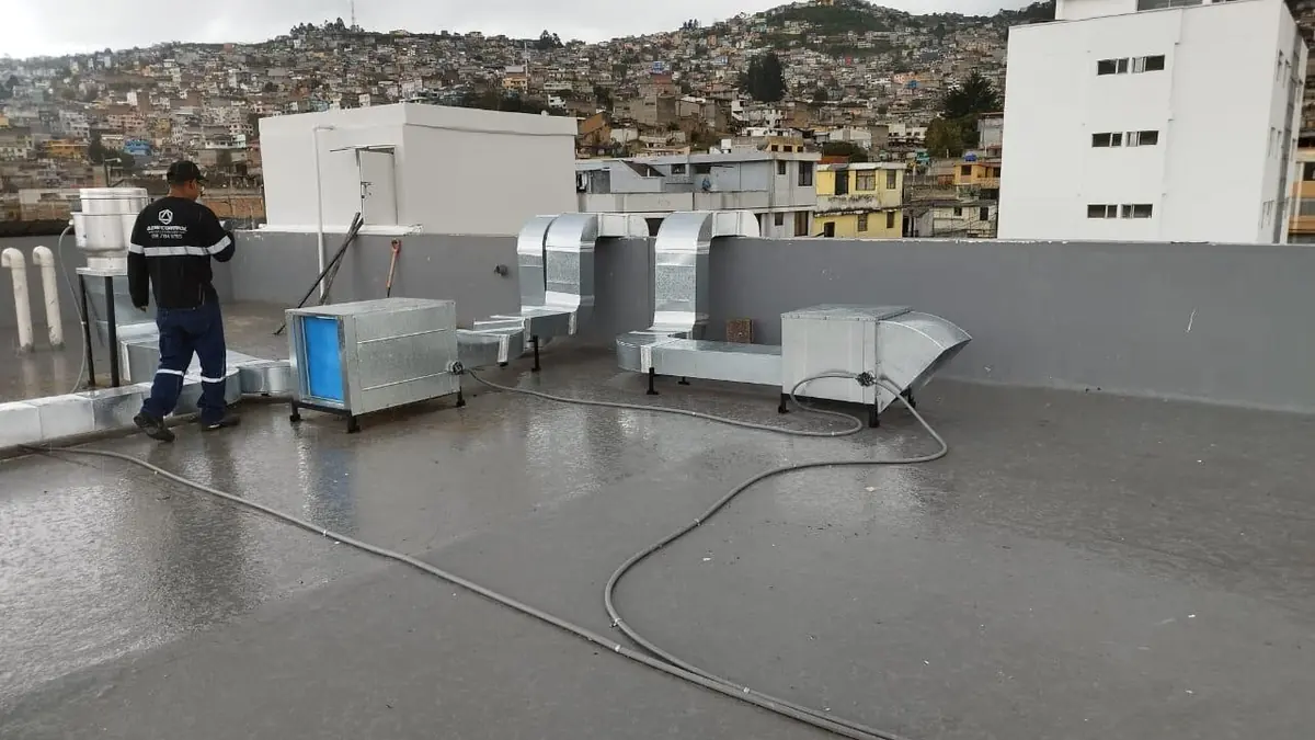 Terraza con ductos y equipos de ventilación instalados, con la ciudad de fondo